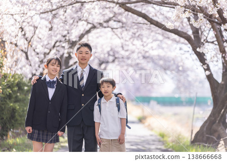 走在櫻桃開花的公園的新的新生和步行者 走在櫻桃開花的公園的新的新生和步行者 138666668