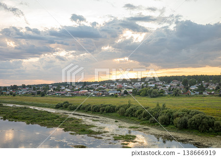 View to waterlogged river bank with near rural settlement at sunset View to waterlogged river bank with near rural settlement at sunset 138666919