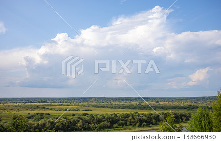 Expansive green landscape under a blue sky with fluffy white clouds Expansive green landscape under a blue sky with fluffy white clouds 138666930