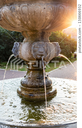 Close up ornate stone fountain with lion head spouts and flowing water Close up ornate stone fountain with lion head spouts and flowing water 138666932