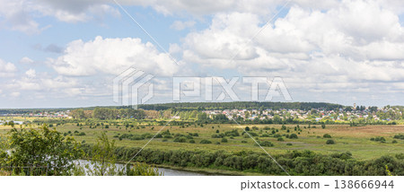 Panoramic view of rural landscape with river and village under cloudy sky Panoramic view of rural landscape with river and village under cloudy sky 138666944