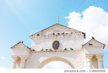 Architectural arch of temple gate with doves under the blue sky and white clouds 138666949