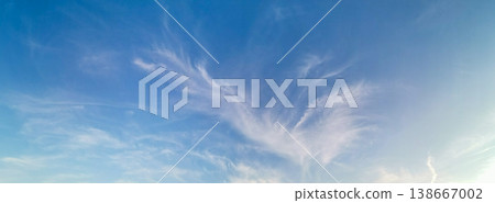 Blue sky with wispy clouds creating a serene atmosphere at sunset Banner 138667002