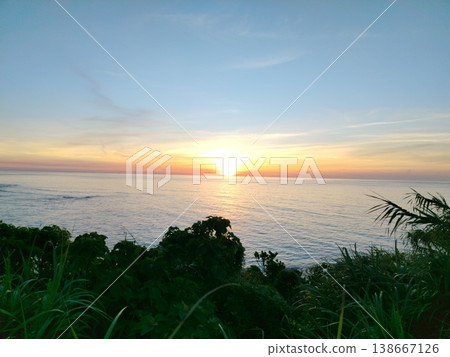 A scene of the sunrise over the sea and gentle waves. A scene of the sunrise over the sea and gentle waves. 138667126