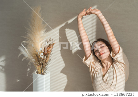 一個女人在早晨的陽光下伸展 138667225
