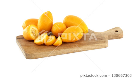 Fresh kumquats On Wooden Cutting Board With Sliced Fruit On White Background 138667303