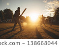 Cricket match during sunset with players batting 138668044