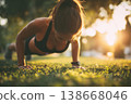 Determined young woman performing push-ups during outdoor fitness workout 138668046