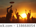 Friends playing frisbee outdoors at summer sunset 138668054