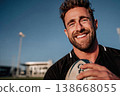 Young smiling man in sporting attire holding rugby ball 138668055