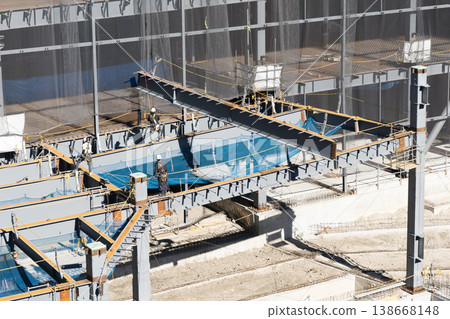 A scene from a steel frame construction site showing workers guiding a suspended load with ropes and crane lifting operations (9) A scene from a steel frame construction site showing workers guiding a suspended load with ropes and crane lifting operations (9) 138668148