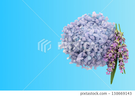 Lavender salt sits next to lavender flowers on a blue surface Lavender salt sits next to lavender flowers on a blue surface 138669143