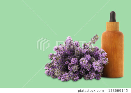 Lavender flowers and a wooden bottle on green Lavender flowers and a wooden bottle on green 138669145