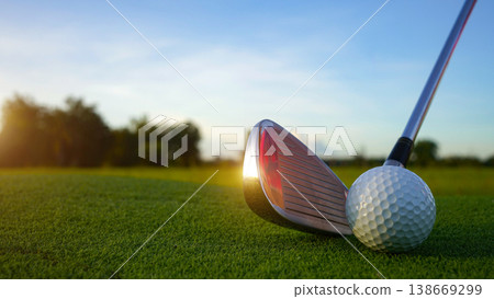 Golf clubs and balls on a green lawn in a beautiful golf course with morning sunshine. Golf clubs and balls on a green lawn in a beautiful golf course with morning sunshine. 138669299