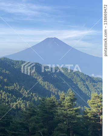 初夏時節，富士山巍峨聳立於山脈之上，構成了一幅狹長而美麗的深藍色山峰的壯麗景色。 138669472