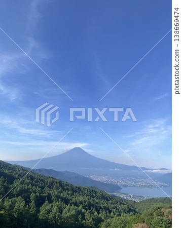 在廣闊無垠的蔚藍天空下，山腳下是鬱鬱蔥蔥的森林，河口湖水盈盈，遠處是雄偉壯麗、綿延不絕的富士山，此時正值初夏。 138669474