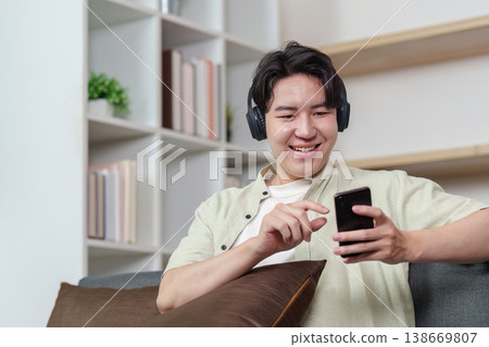Young man enjoying smartphone entertainment with headphones 138669807