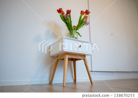 Minimalist interior with tulip bouquet in glass jar on bedside table modern Scandinavian home decor Minimalist interior with tulip bouquet in glass jar on bedside table modern Scandinavian home decor 138670255