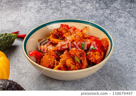 Spicy chicken curry in a bowl surrounded by fresh bell pepper, avocado, and bitter melon Spicy chicken curry in a bowl surrounded by fresh bell pepper, avocado, and bitter melon 138670497