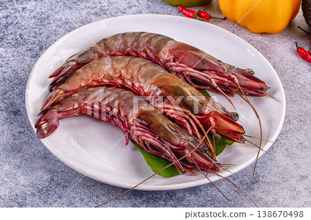 Fresh raw giant red prawns on a plate with chili peppers and tropical vegetables. 138670498