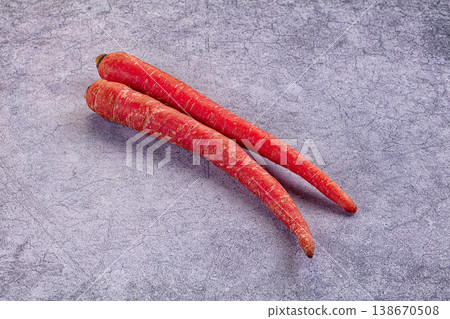 Two raw red carrots on a rustic wooden table. Fresh organic root vegetables. Two raw red carrots on a rustic wooden table. Fresh organic root vegetables. 138670508
