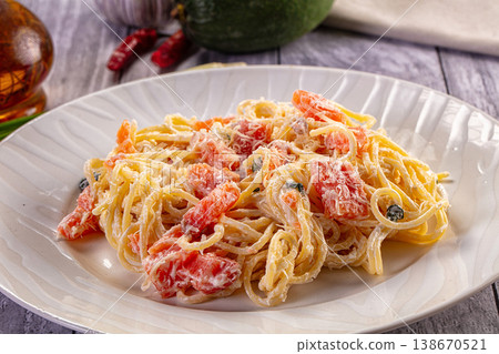 Creamy Spaghetti with Diced Salmon and Parmesan Cheese on a White Plate 138670521