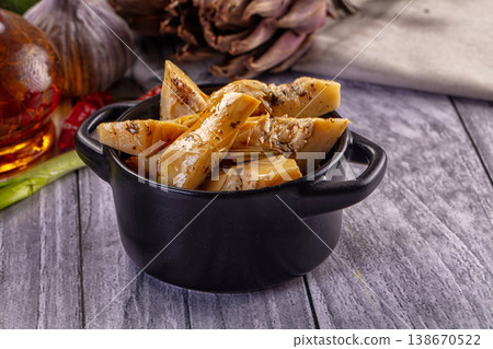 Gourmet appetizer of marinated artichoke hearts on a rustic wooden table 138670522