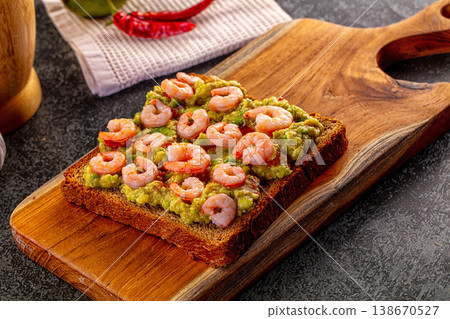 Gourmet open-faced sandwich with shrimp and guacamole on a wooden board Gourmet open-faced sandwich with shrimp and guacamole on a wooden board 138670527