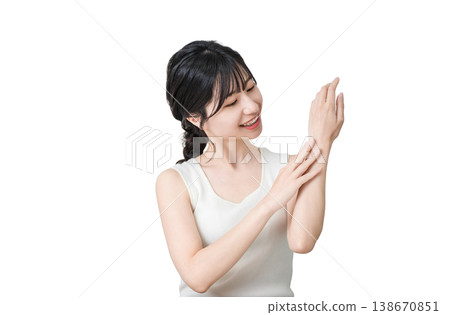 Japanese woman applying hand cream to the back of her hand (hand care, skin care) 138670851