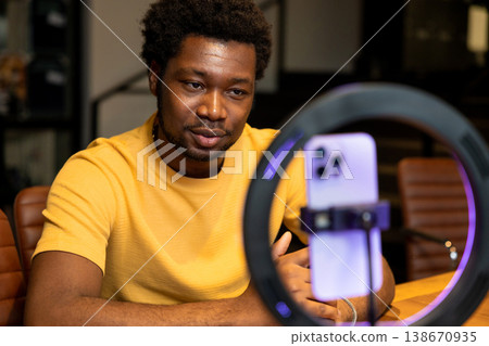 African American blogger looking at smartphone during video recording 138670935