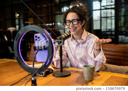 Smiling female influencer gesturing during video stream recording 138670979