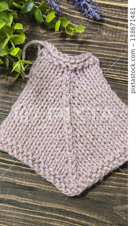 A raised openwork pattern knitted with colored yarn on a wooden background. A raised openwork pattern knitted with colored yarn on a wooden background. 138671481