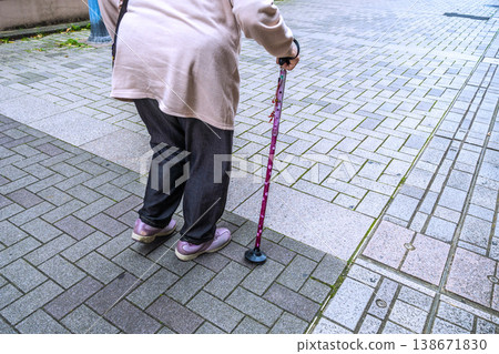 在日本橫濱的城市景觀中，一位老婦人拄著拐杖，沿著長長的鋪砌人行道，在縫隙間蹣跚而行……生命是什麼？ = 橫濱市 138671830