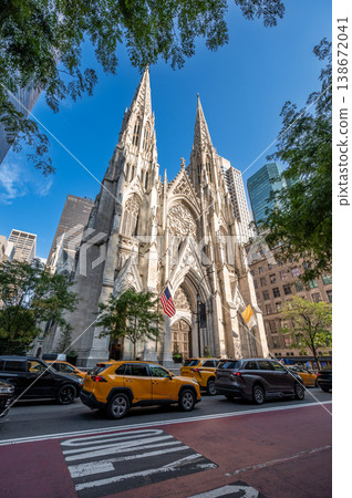 New york, usa august 14,2024. St. Patrick's cathedral, a neo gothic landmark, standing tall among modern skyscrapers with traffic passing on fifth avenue New york, usa august 14,2024. St. Patrick's cathedral, a neo gothic landmark, standing tall among modern skyscrapers with traffic passing on fifth avenue 138672041
