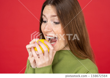 Woman biting sour lemon with funny facial expression 138672564