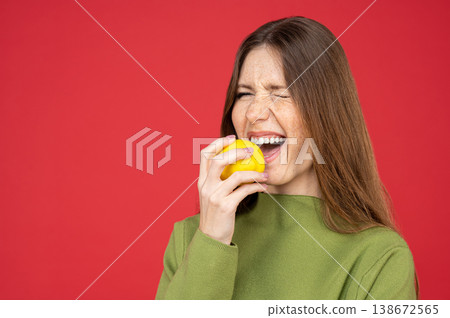 Surprised woman tasting fresh lemon grimacing from sourness 138672565