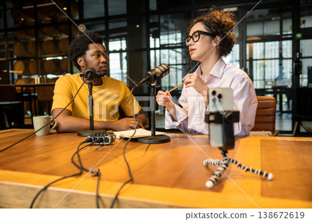 Diverse colleagues recording video podcast on smartphone Diverse colleagues recording video podcast on smartphone 138672619