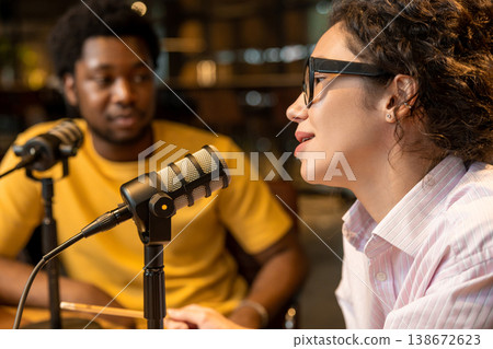 Woman host speaking into microphone and looking at guest 138672623
