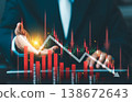 Close up of businessman hand with falling stock market chart, red bars and downward arrows. Financial crisis, economic recession, and investment loss concept. 138672643