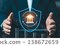 Businessman protecting bank icon inside blue shield with stacks of coins, financial insurance and capital protection concept against market volatility. 138672659
