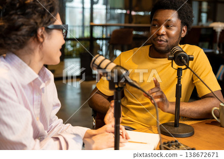 Man talking to female colleague during podcast interview Man talking to female colleague during podcast interview 138672671