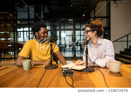 Colleagues smiling and talking in microphones during interview Colleagues smiling and talking in microphones during interview 138672676