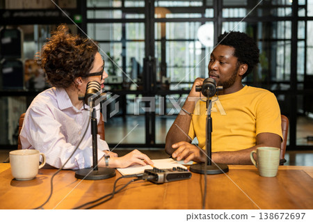 Young woman interviewing African American man for podcast 138672697