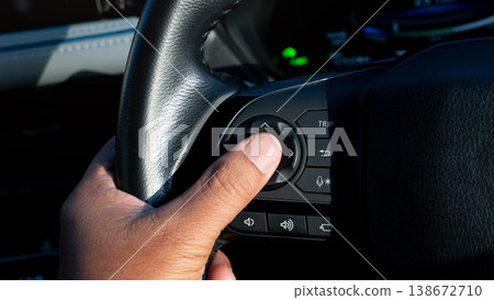 Silhouette intense light reflected on the driver hands as they pressed the buttons on steering wheel. Press finger on the center confirmation button. Feels confirm and clear of control. 138672710