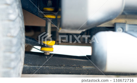 Rear suspension assembly of a Passenger Pickup Vehicle has yellow rubber bushings. After prolonged use these rubber bushings can become warped. Rear suspension assembly of a Passenger Pickup Vehicle has yellow rubber bushings. After prolonged use these rubber bushings can become warped. 138672716