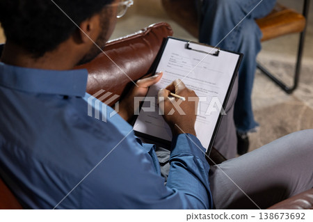 Man writing notes on clipboard 138673692