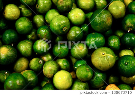 Close-up of fresh green limes (jeruk nipis) at a traditional Indonesian market. Close-up of fresh green limes (jeruk nipis) at a traditional Indonesian market. 138673710