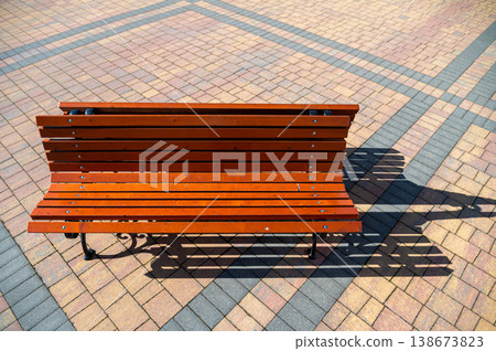 Wooden bench on brick pavement in park during daytime 138673823