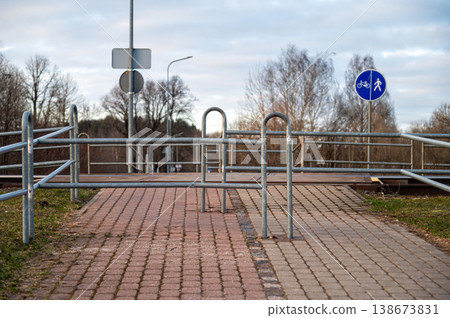 Pedestrian crossing on railway tracks with railings and signs near the path Pedestrian crossing on railway tracks with railings and signs near the path 138673831