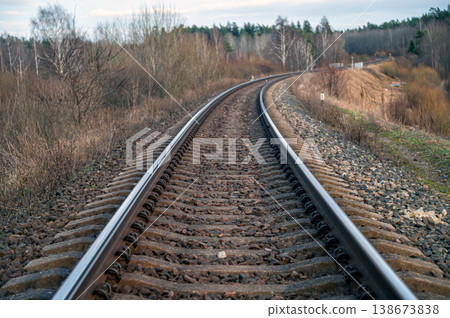 Curving railway tracks through a wooded area in early evening light Curving railway tracks through a wooded area in early evening light 138673838